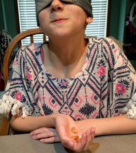 child blindfolded for food tasting