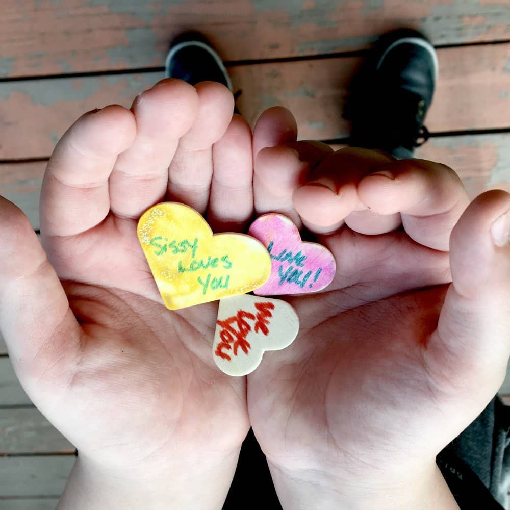 child holding heart shaped wood chips